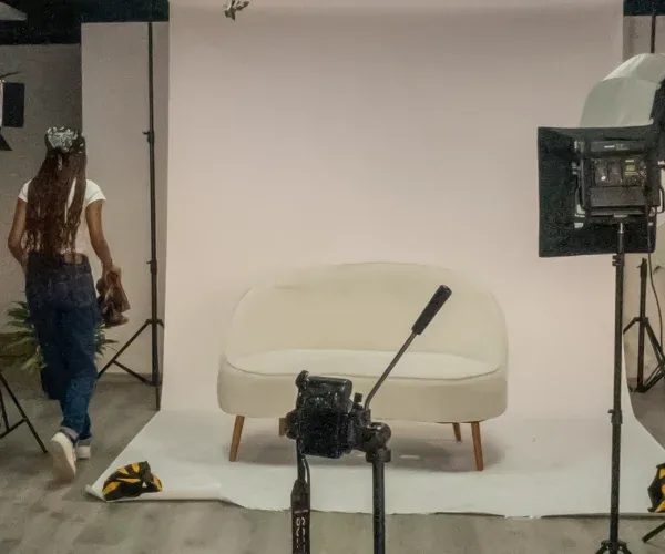 Set de fondo blanco con cámara y mobiliario para sesiones de foto y video